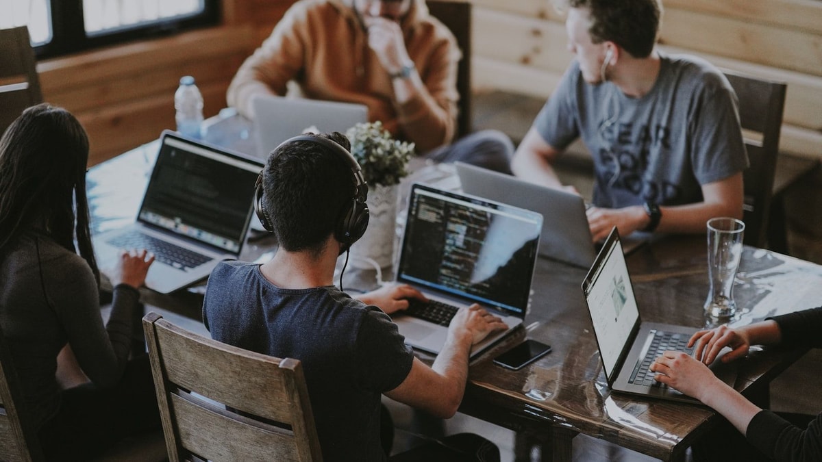 Équipe tech diverse travaillant ensemble sur laptop
