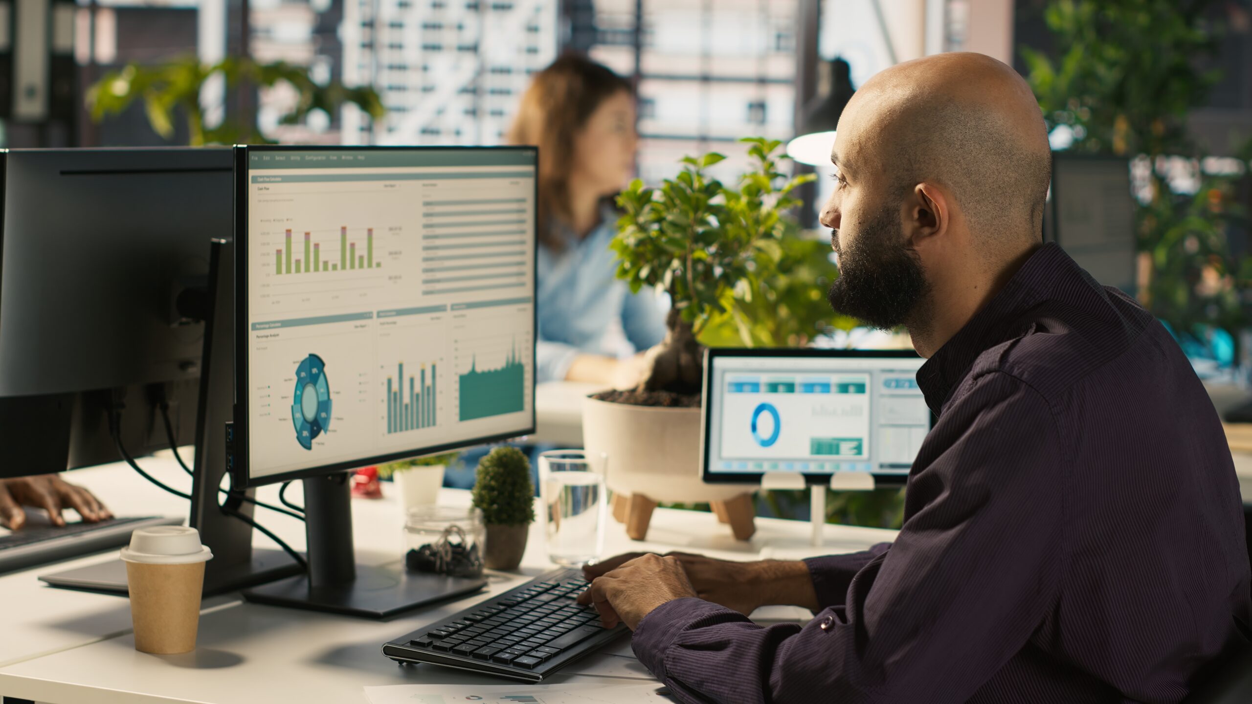 Employee editing documents on desktop computer at office desk Comment recruter un Data Analyst en 2025 – Le guide complet