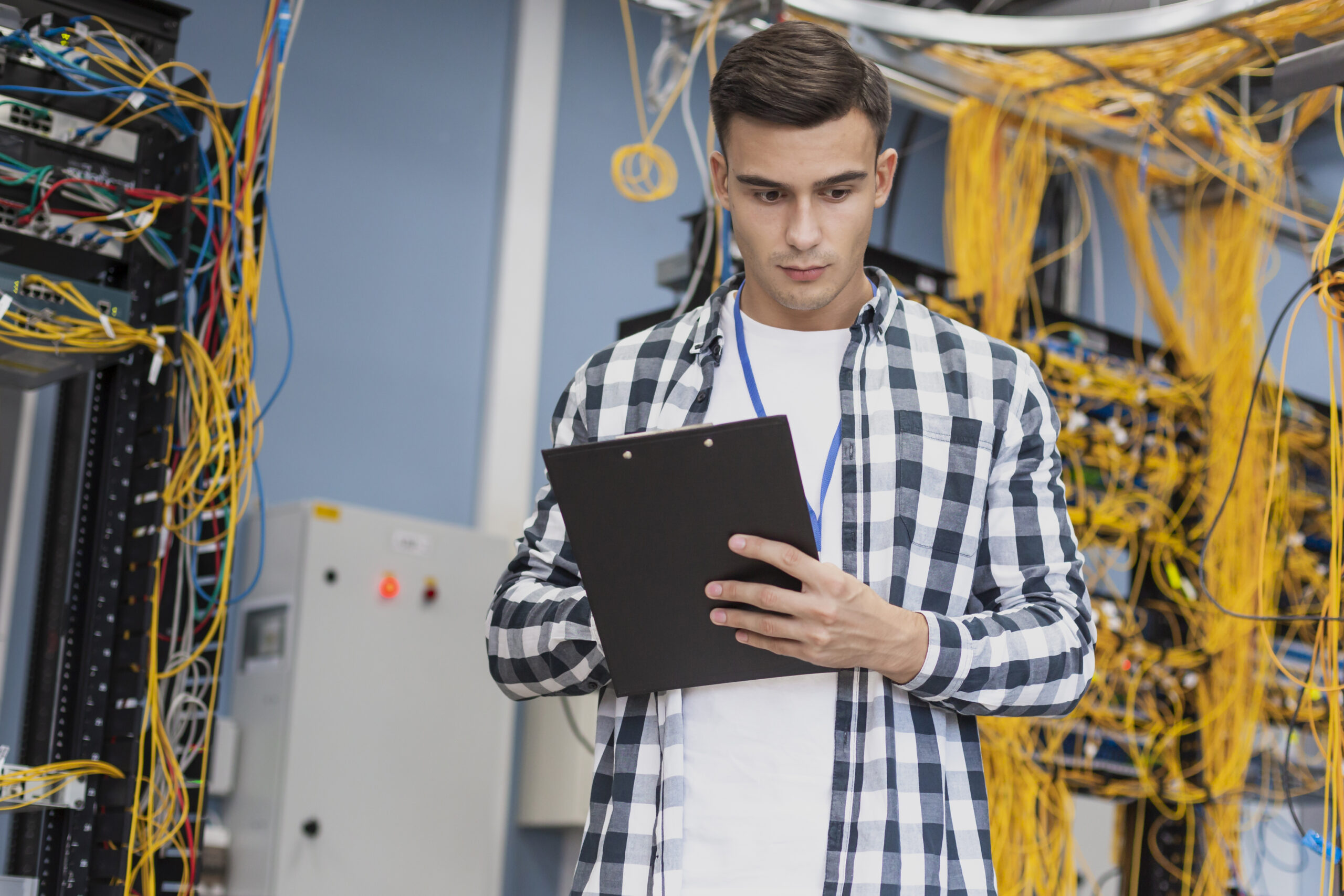jeune-ingenieur-dans-la-salle-des-serveurs-plan-moyen Comment recruter un ingénieur systèmes et réseaux ? Le guide complet